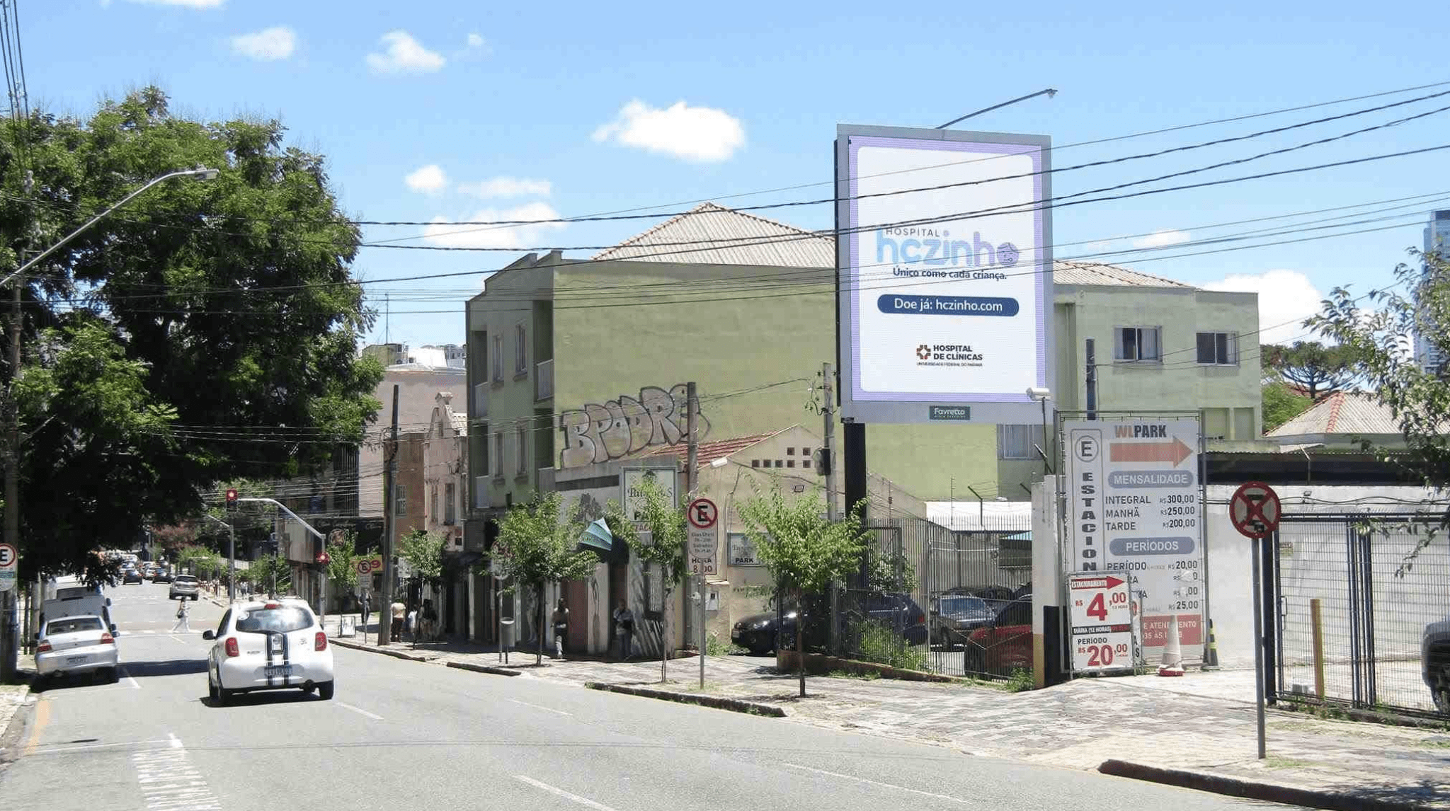 Rua com edifícios e outdoor publicitário.