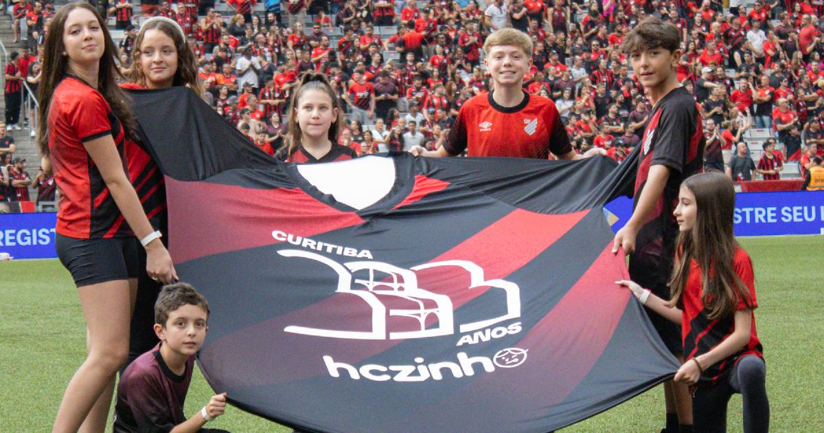 Crianças segurando réplicas das camisas comemorativas dos 333 anos do Atletiba pelo HCzinho — Foto: João Heim/UFPR